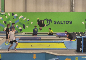 Uczniowie skaczący na trampolinach.