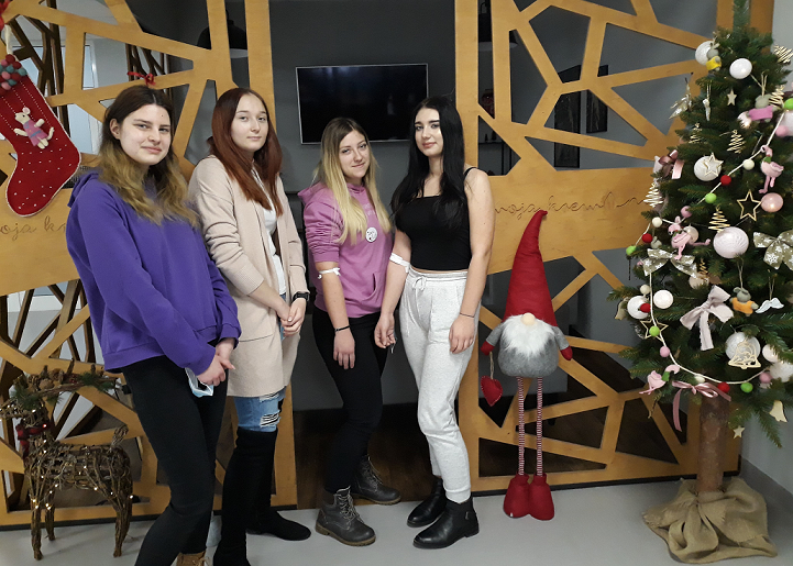 Cztery Honorowe Dawczynie Krwi z ZSETH w Łodzi na tle dekoracji świątecznych