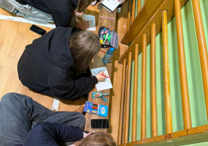 Uczniowie wypisujący kartki świąteczne