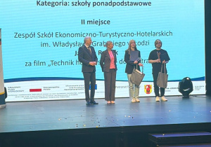 Uczennica na scenie z nagrodą